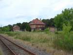 Die zugewachsenen früheren Rangier- und Gütergleise, sowie das Bahnhofsgebäude in Laucha am 12.07.2009.